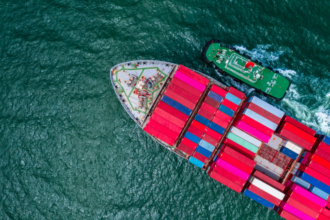 Global Export Company - Cargo ship fully loaded with colorful shipping containers going for Export